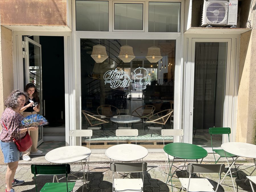 Clientes à l'entrée de la salle, tables vertes et blanches
