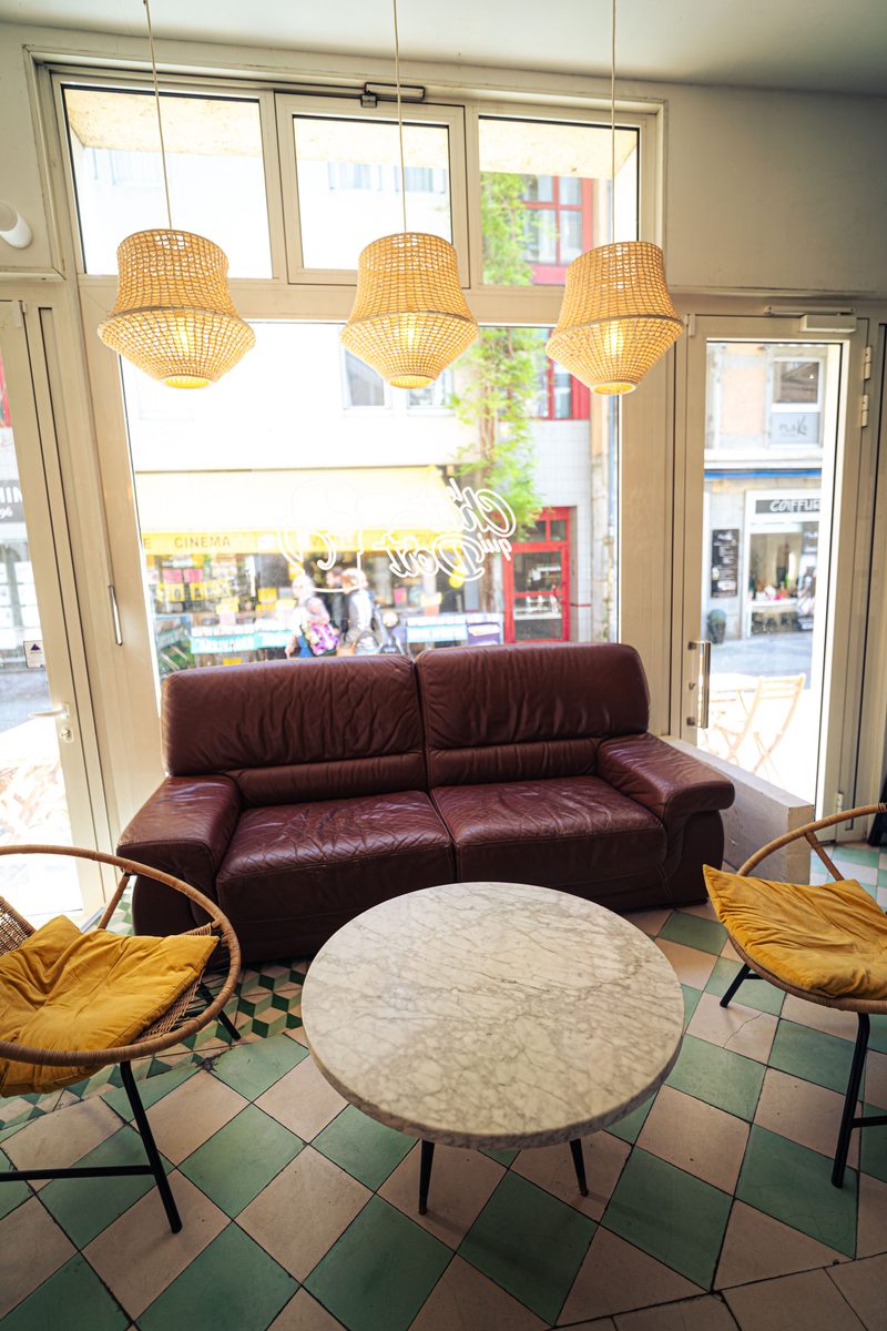 Le coin salon : canapé en cuir, fauteuils en rotin et table basse en marbre