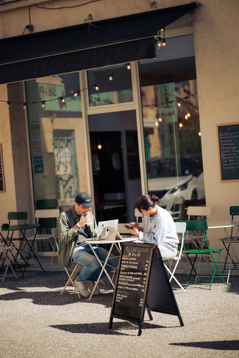 La terrasse du Chat qui dort au soleil, clients attablés devant la vitrine